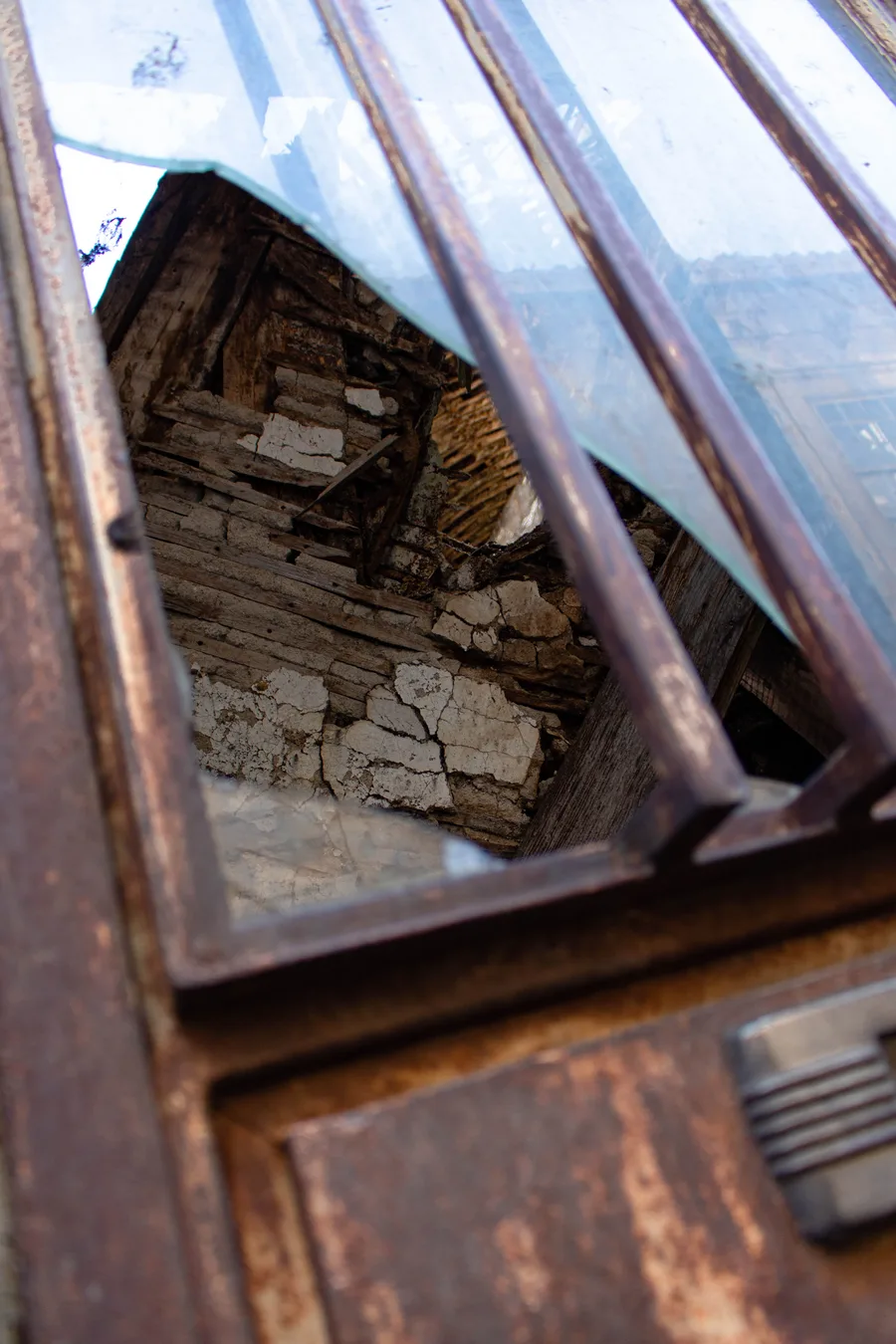 Low-angle view through a broken corrugated roof gap