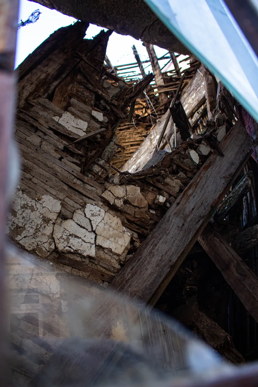 Low-angle view of a collapsed roof structure against the sky